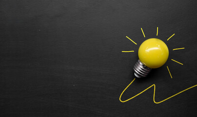 creativity inspiration, ideas concepts. light bulb on blackboard background. top view