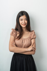 Fototapeta premium beautiful asian girl with long hair standing while crossing hands with an isolated background