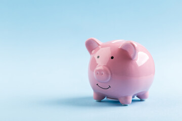pink piggy bank on blue background.  The concept of saving money or savings, investment