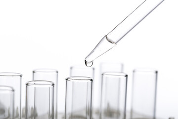 pipette with a drop and scientific laboratory test tubes in a research laboratory.