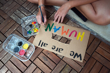 America USA - white latin girl holding sign we are all human protest and manifest after the killing...