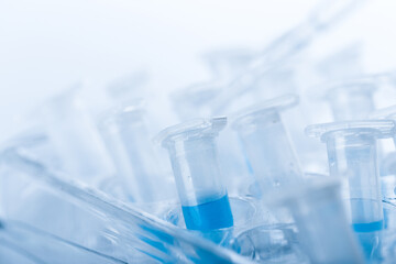 microbiological pipette in the genetic laboratory. study of a virus or vaccination. blue tinted.