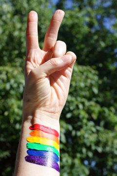 LGBT Pride Month, rainbow flag with victory hand concept.