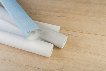 rolls of multi-colored paper wallpaper on a wooden table
