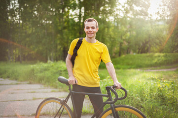 Obraz premium A young Man stopped to rest With his Bicycle in a public Park.