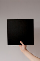 Hands hold a  sheet. Empty space for the label.