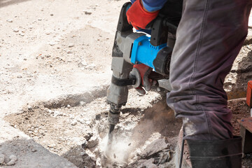 construction worker with jackhammer digging concrete roads