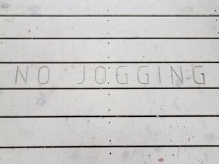 no jogging sign on brown wood boardwalk or ground