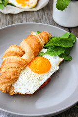 Morning Breakfast with scrambled eggs, croissant and rucola