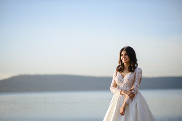 Fototapeta na wymiar Portrait of a bride on the background of the lake.