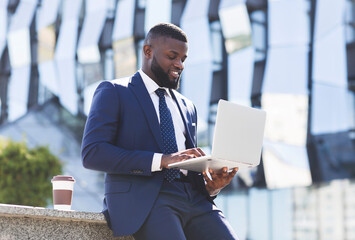 Happy African American Entrepreneur Using Laptop During Coffee Break Outdoors