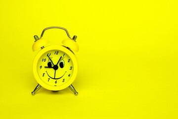 yellow alarm clock on yellow background