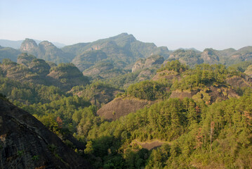 Wuyishan mountains in Fujian Province, China. Scenic view over the peaks of Wuyi mountains. A classic view of the hills from Roaring Tiger Rock. Wuyishan is a UNESCO World Heritage site in China.