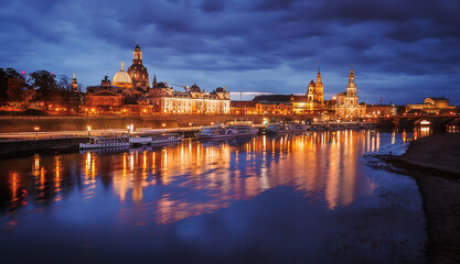 Fantastic colorful sunset in Dresden with dramatic sky, over the Elbe river. Old Town glowing in lighten reflected in calm water. Picturesque unusual scene. Creative image. Famouse Dresden buildings