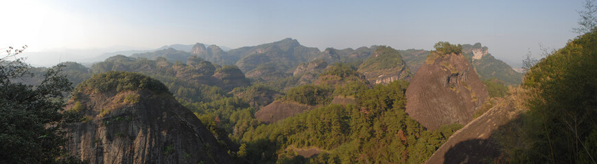 Fototapeta na wymiar Wuyishan mountains in Fujian Province, China. Scenic view over the peaks of Wuyi mountains. A panoramic view of the hills from Roaring Tiger Rock. Wuyishan is a UNESCO World Heritage site in China.