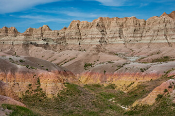 Reds, yellows, oranges and browns color the arid rocks, ridges and cliffs in the rugged Badlands of South Dakota.