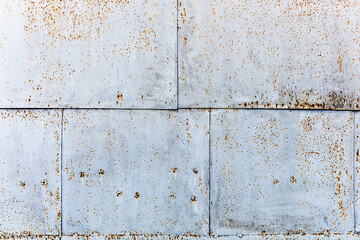 Surface texture of old metal sheets fastened with nails. Crumpled rusted metal sheets. Rusty nails. Background