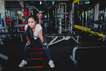 Fototapeta na wymiar Close up image of beautiful Asian women Standing resting after a workout in the fitness center The backdrop is various equipment in the gym. Concept: Sporty girl in the gym.