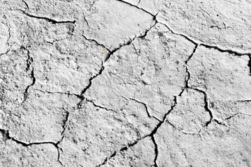 Dried and Cracked ground. Dry soil in arid areas. Cracks in the ground. Drought concept. Black and white photography. View from above. Closeup