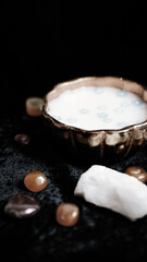 Milk and blue flowers in a bronze bowl.