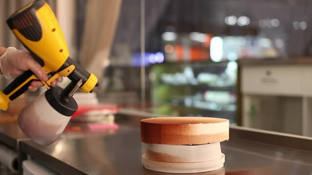 Spraying chocolate on a cake. Cake making process
