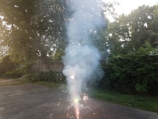 Fototapeta na wymiar lit colorful fireworks on asphalt driveway with smoke