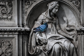 Piccione appollaiato su una statua in Piazza del Campo a Siena