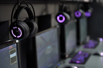 Professional gaming headphones with bright side led lights hanging off the monitor.