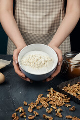 Woman in checkered apron cooking tart. Cook mixing ingredients for cooking tart, cookies, and bakery.