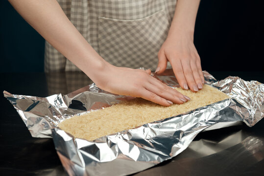 Woman's hands filling prepared pastry with pastry weights for save pie shape while baking