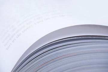 Pages of an open book with with narrow depth of field on white background. Blurred text