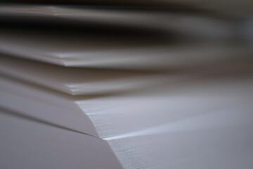 Close up on the edge of an open book with narrow depth of field. Focus on right side of papers. 