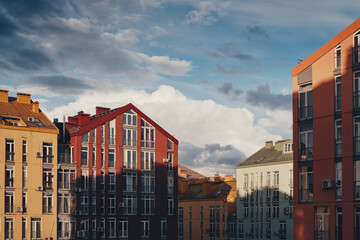 Roofs of colourful houses and rain clouds on a blue sky. Comfort town.