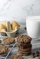 chocolate chip cookies near a glass of fresh milk with some ingredient, with copy space