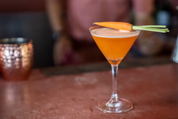carrot mocktail are mixed and ready to serve on red bar.
