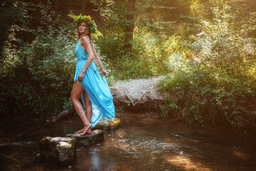 a beautiful young woman celebrates in the woods the solstice day