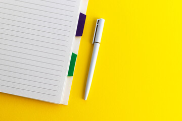 Pen and blank notepad on yellow background. Notebook for ideas message, list and inspiration. Flat lay with copy space.