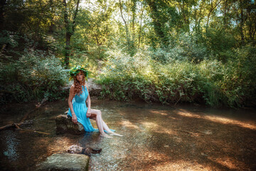 a beautiful young woman celebrates in the woods the solstice day