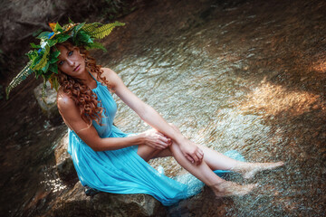 a beautiful young woman celebrates in the woods the solstice day
