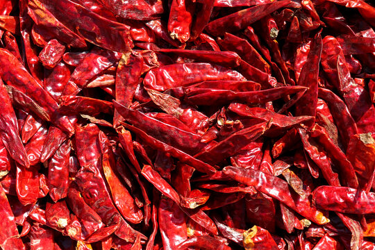 Pile of dried hot red chilies or chilli cayenne pepper for making chili powder spices background.