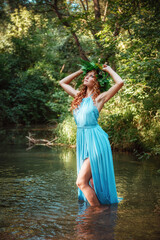 a beautiful young woman celebrates in the woods the solstice day