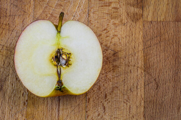 Close up of half red apple fruit on a wooden background