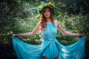 a beautiful young woman celebrates in the woods the solstice day