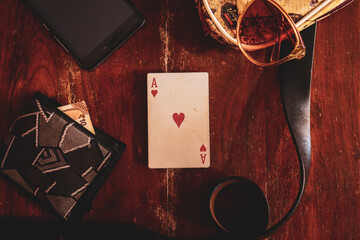 Ace of Hearts card kept in the centre of a wooden table background for playing illusion, magic trick. Illusionist. Flat lay.