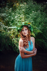 a beautiful young woman celebrates in the woods the solstice day