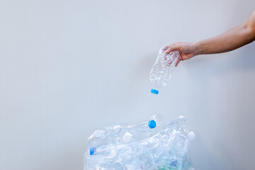 Hand putting plastic bottle in plastic bag for recycling,plastic bottle garbage for recycling concept reuse.