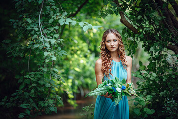 Obraz na płótnie Canvas a beautiful young woman celebrates in the woods the solstice day