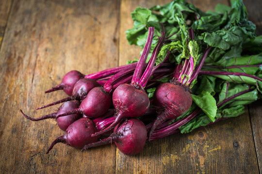 Fresh red organic beets on a wooden table