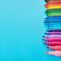 Row of colored pencils with copy space on blue background