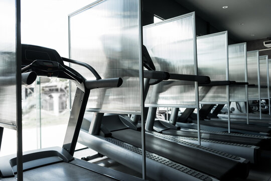 New normal of GYM or FITNESS. Partition beside the electric treadmill to prevent the spread of the disease Covid 19 or Coronavirus. New normal exercise concept.